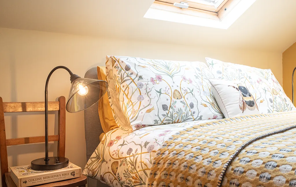 Glass shade table lamp on a bedside table used for bedroom lighting.